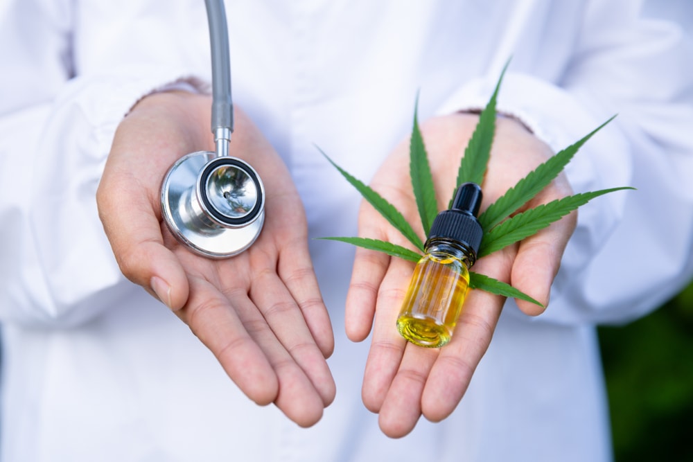 doctor holds stethescope in hand and cbd in another hand